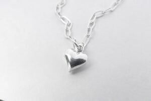Silver heart jewelry on white surface